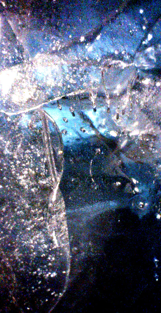 Abstraction is a challenge for man, because man wants to find meaning for what he/she sees. The left side is like a light blue waterfall with smallish white ice-like pieces floating over it. They kind of grow upwards like trees. In the upper part, the pieces are more sparse than in the lower part but they cover a wider area. They spread like branches of a deciduous tree. At the bottom, there is another equally thick horizontal tree that is made up of pieces. It has a black background and is darker than the other one. As if a light would have come through the pieces. On the right a thin blue mist line rises upwards.The close-up shows ice crystals and dim light as a result of it getting colder. 